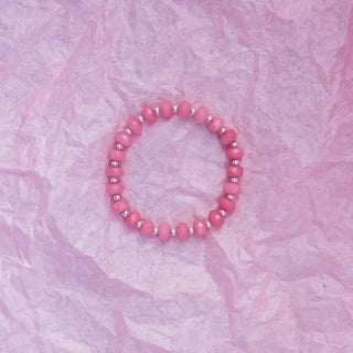 Pink beaded bracelet on a textured pink background