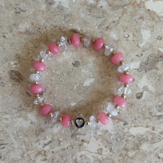 Beaded bracelet with pink and clear beads on a textured stone surface